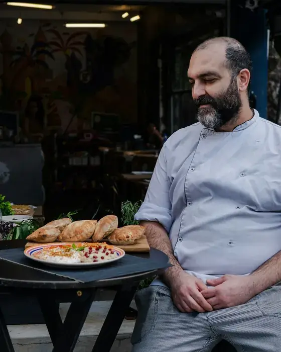 Cozinheiro com uma pizza acabada de sair do forno